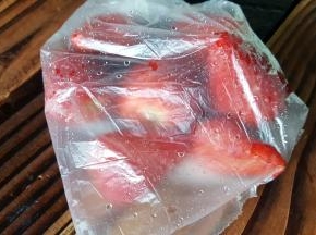 在制作冰沙前，提前将草莓洗好去蒂，放在保鲜袋中冷冻备用。