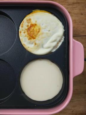 接着给刚才煎鸡蛋的圆盘里倒少量面糊。