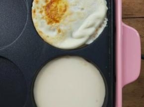 接着给刚才煎鸡蛋的圆盘里倒少量面糊。