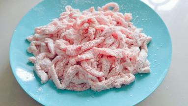 在抖掉多余的淀粉，这个时候如果有时间再静止几分钟，让淀粉吸附一下，炸的时候不容易脱落。