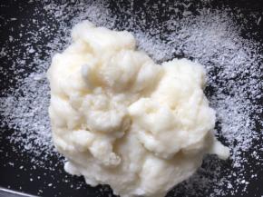 将冷却的牛奶团放入盘中的椰蓉上