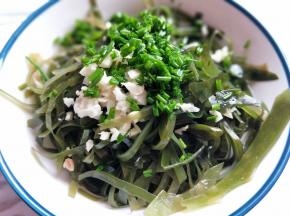 将淋干水份的海带放入器具中，加入切碎的蒜和葱花，姜末。