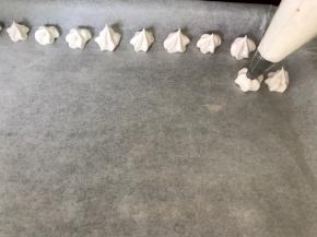 拧紧裱花袋的口，将蛋白糊挤在铺好油纸的烤盘上，大小形状随自己喜好