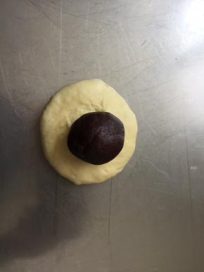 取一个面团，压扁，放一个豆沙馅儿