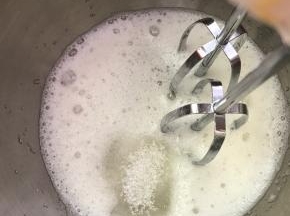 打发至白色时，加入剩下的白糖，继续打发