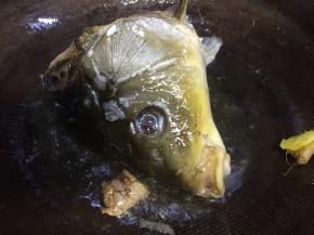 油温六成放入鱼头老姜煸炒，炒至鱼头变色