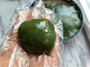 取一块面团，包上芒果，包起来即可。