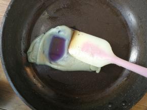 取一小块需要调制成蓝色的绿豆沙，加入蝶豆花水，在平底锅中略微翻炒均匀，同时把加入的水份收干，最后团成蓝色的绿豆沙面团