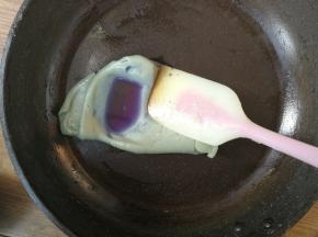 取一小块需要调制成蓝色的绿豆沙，加入蝶豆花水，在平底锅中略微翻炒均匀，同时把加入的水份收干，最后团成蓝色的绿豆沙面团