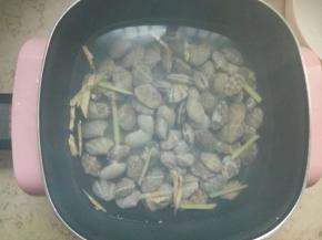 放一锅水，加入姜丝和少量料酒煮开，倒入浸泡过的花蛤煮开。