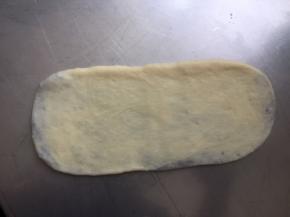 压扁，用擀面杖擀成长方形，要轻一些，防止擀露豆沙馅儿