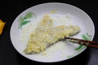 裹好浆糊的鱼块，放入面包糠上面，轻轻按压，让鱼块裹上面包糠；