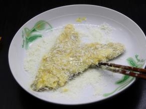 裹好浆糊的鱼块，放入面包糠上面，轻轻按压，让鱼块裹上面包糠；