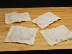 在盖上一张云吞皮，把边捏紧，这是做好的；