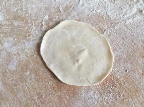 压扁后擀成中间厚边缘薄的面皮
