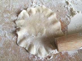 擀好面皮后，用擀面棍的头再将面皮的边缘擀薄成荷叶边