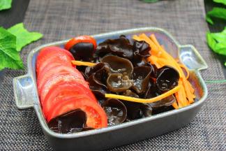 在把切好的西红柿片摆好，撒上胡萝卜丝；