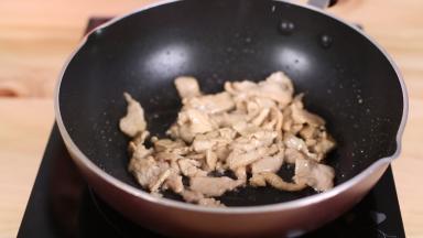 准备一个炒锅，放入适量的食用油，油热后放入腌好的肉片，快速翻炒，炒至肉片变色后马上盛起。