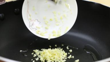 锅里重新下油，加入适量的食用油，放入蒜末，小火翻炒。