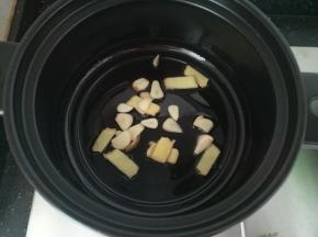 砂锅热油，放入姜片爆香，后加入蒜片。