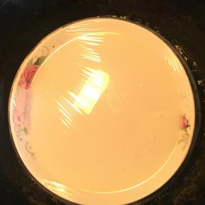 煮沸的糖浆倒入步骤1中，边打边搅匀。搅匀后倒入盘内，盖上保鲜膜，冷水上锅蒸25分钟。