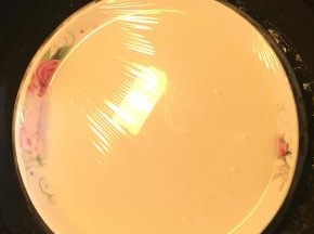 煮沸的糖浆倒入步骤1中，边打边搅匀。搅匀后倒入盘内，盖上保鲜膜，冷水上锅蒸25分钟。