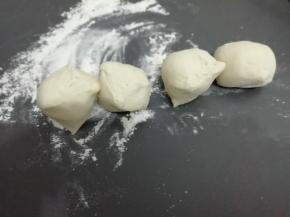 醒好的面团分成大小均匀的小面团，擀面杖擀成圆片 ，然后将馅料放入中间包好