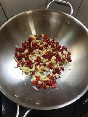 锅烧热倒入适量的油，放入蒜瓣，生姜，花椒，干辣椒小火煸炒出香味儿。