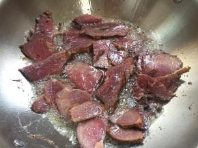 锅烧热倒入适量的油，放入卤好的牛肉中火慢慢煸炒至微焦，即可捞出沥干油分备用。