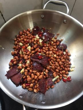 倒入炒好的花生米翻炒片刻。