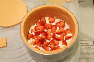 将奶油挤入蛋糕内，放上草莓粒