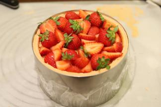 一样挤入奶油和放上草莓粒，盖上第三片圆形蛋糕片，挤上少许奶油，摆放好草莓和蓝莓