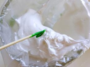 挖四分之一的蛋白到裱花袋里面，用牙签调一点点色素放在蛋白上