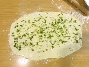 葱末均匀的撒在抹好油的饼皮上。