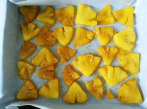 将菠萝摆在铺好油纸的烤盘上备用