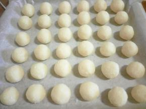 现在就可以抓球球了，先把椰蓉抓紧一些，然后整理成圆形。一个球大概10克左右，第一个过秤称一下，之后根据第一个的大小抓就行。烤箱小，一盘搞定了，放入预热好的烤箱180度，大概烤了25分钟。