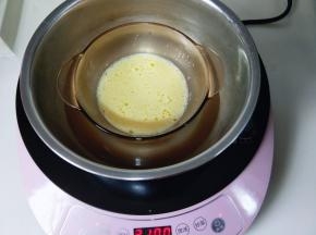 将牛奶和鸡蛋液隔水将白砂糖融化，不停的搅拌，至糖融化即可。