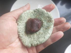 将糯米团用手捏平，放入豆沙。
