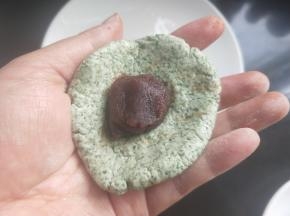 将糯米团用手捏平，放入豆沙。
