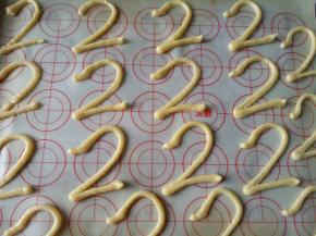 将面糊装入裱花袋，裱花袋剪一个小口，在烤盘上挤“2”