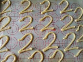 将面糊装入裱花袋，裱花袋剪一个小口，在烤盘上挤“2”