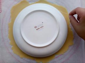 如果有8寸慕斯圈可以直接压出一个圆形，没有慕斯圈也没关系，可以找一个8寸的盘子放在上面，用牙签在周围划一圈。