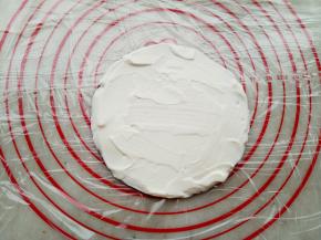 底下铺上保鲜膜，取一张饼皮，奶油涂抹均匀放在保鲜膜上。