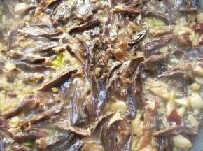 倒入腊鸭心翻炒一下，接着把蒸腊鸭心的蒸汁也倒入。