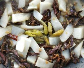 加入野山椒以及野山椒水，继续翻炒，让腊鸭心再次入味。