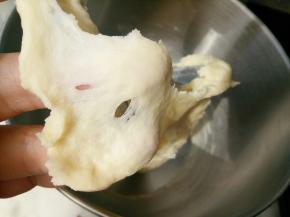 把汤种和主面团除黄油以外的其他材料一起放入厨师机里揉10分钟左右，能拉出这样的膜。这时放入黄油继续揉。