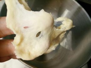 把汤种和主面团除黄油以外的其他材料一起放入厨师机里揉10分钟左右，能拉出这样的膜。这时放入黄油继续揉。