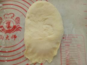 取一份面团擀成牛舌形，然后卷起来。