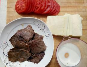 准备好材料，西红柿切片，布列塔尼切片，牛肉用大喜大烤肉酱腌好后上锅煎熟，牛奶倒入量杯里加入1克盐再把鸡蛋打里。