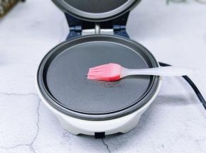 将华夫饼机器连接上电源预热2分钟，再刷上少许橄榄油。